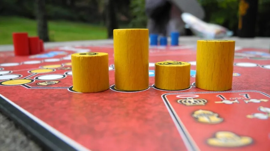 Family playing board games together at home during evening, demonstrating time management for educational activities
