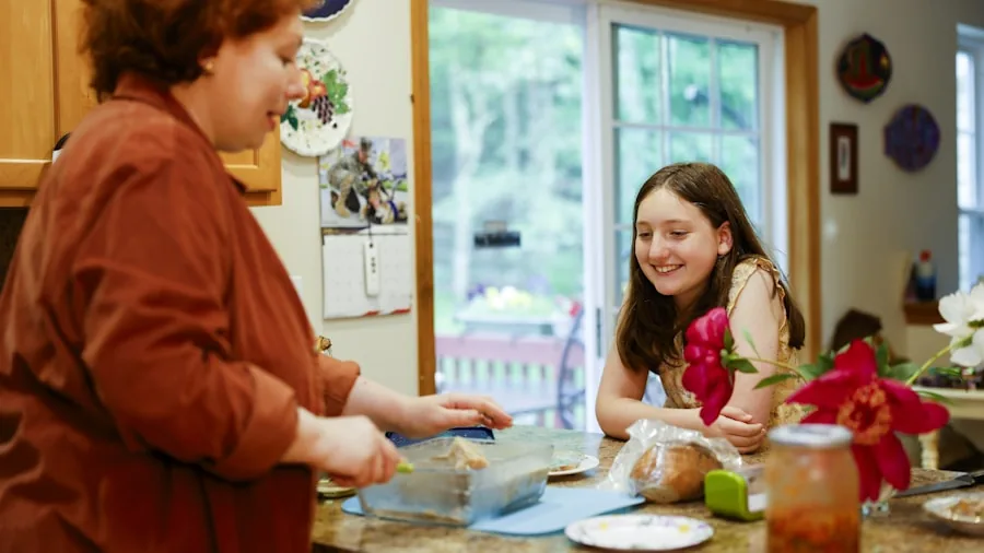 Family preparing meal in modern kitchen with various cooking appliances and fresh ingredients on counter