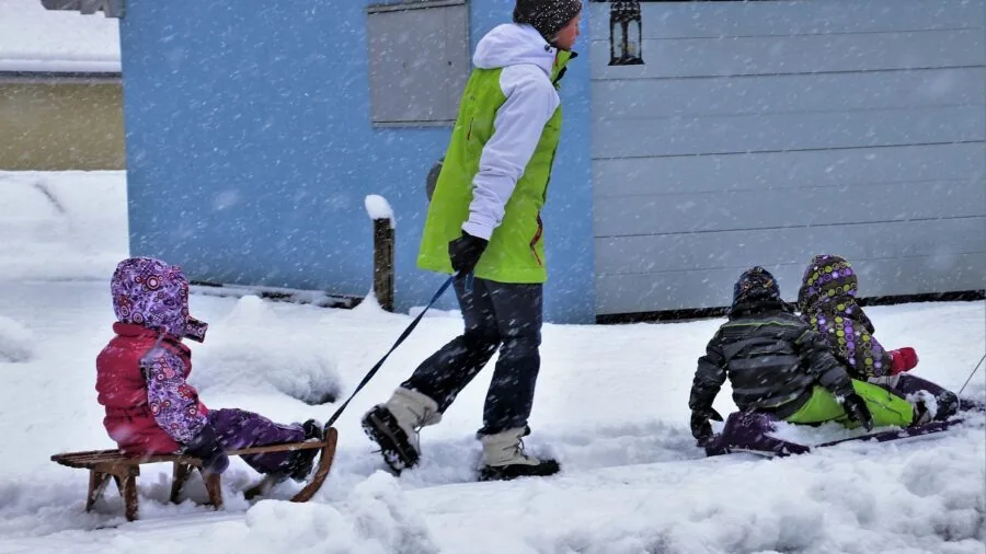 Family sledding down a snowy hill on a winter day