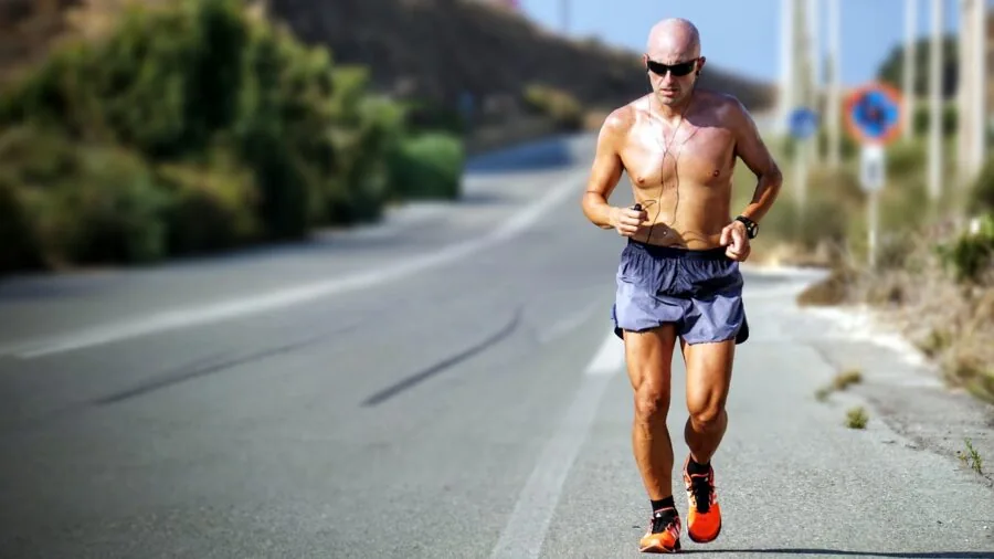 Female runner in athletic wear during hot weather outdoor run, moisture on forehead