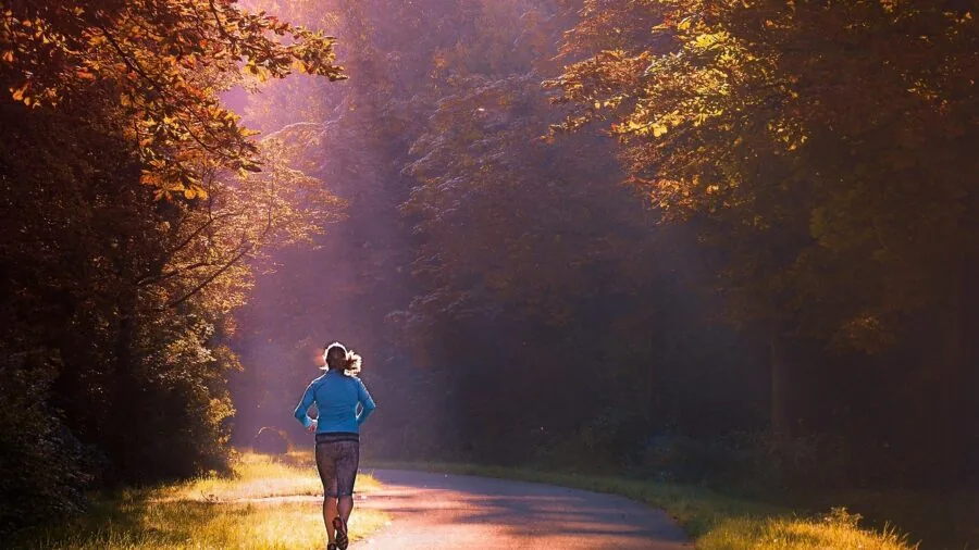 Female runner in motion on outdoor trail during daytime exercise