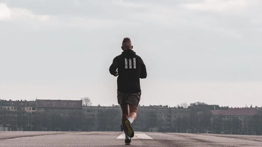 Female runner jogging on trail, focused on form and stability during outdoor run