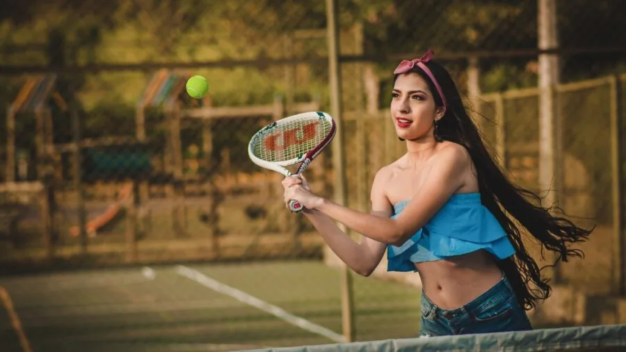 Female tennis player in motion during match, demonstrating athletic movement and performance on court