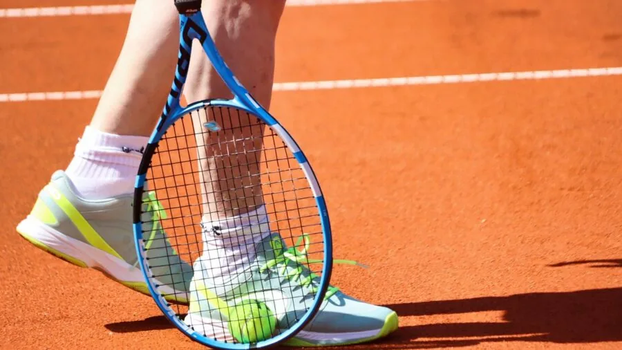 Female tennis player in motion on court wearing a classic tennis skirt
