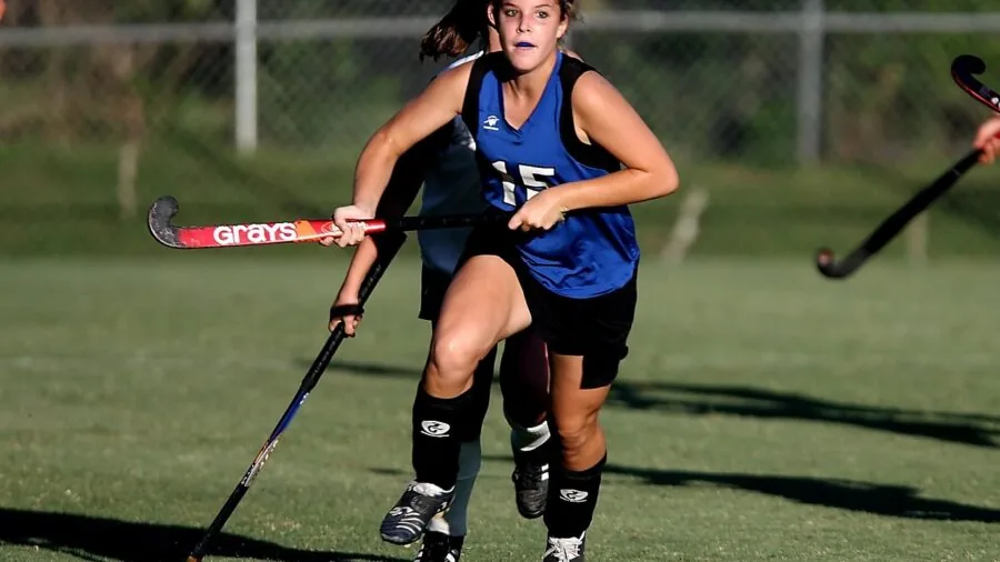 Field hockey player gripping stick during outdoor practice session