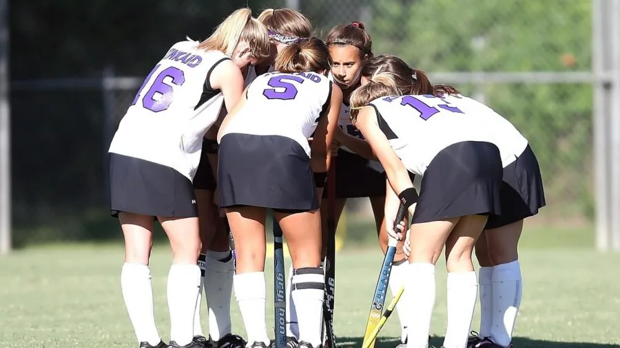 Field hockey player gripping stick shaft during game or practice