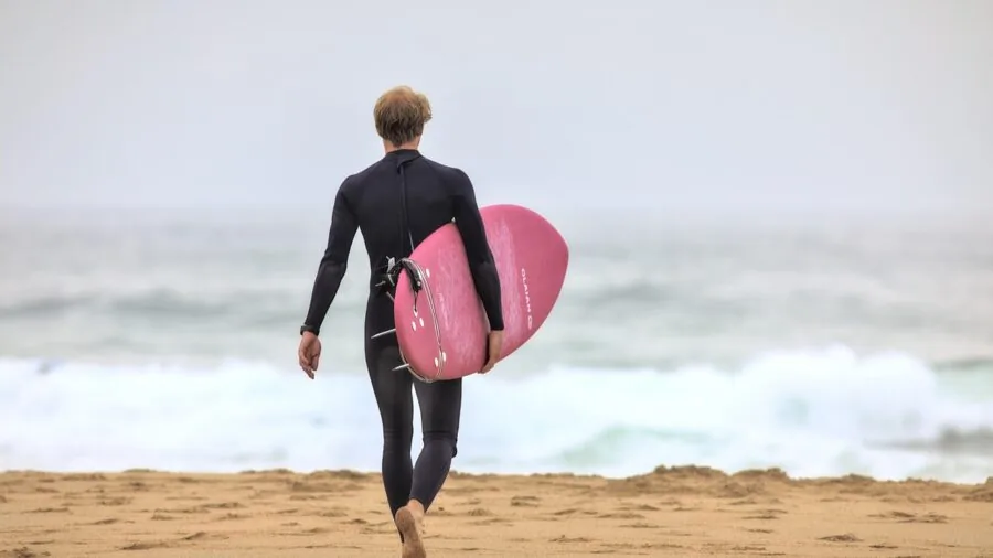 First-time surfer examining different surfboard sizes at the beach