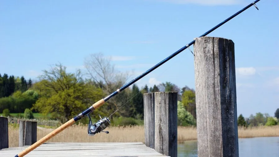 Fisherman casting line into calm water during peaceful outdoor fishing moment