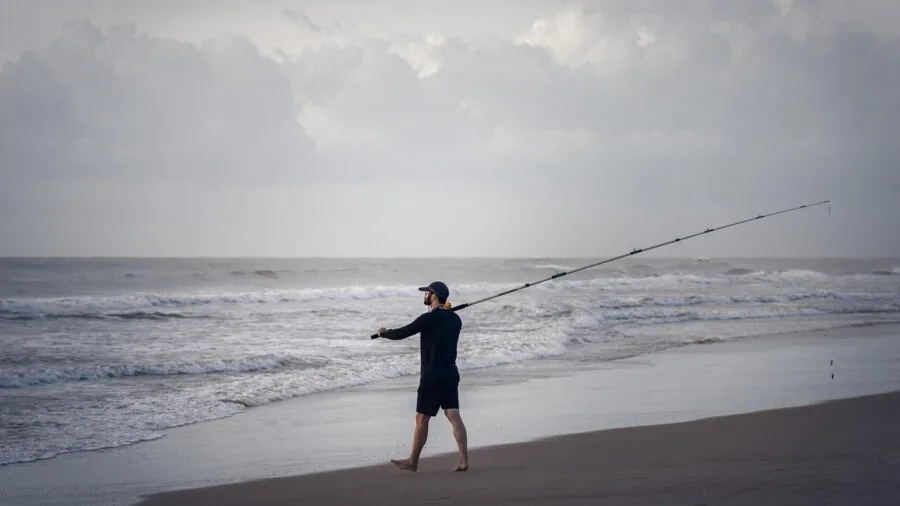 Fisherman casting rod in natural outdoor water setting