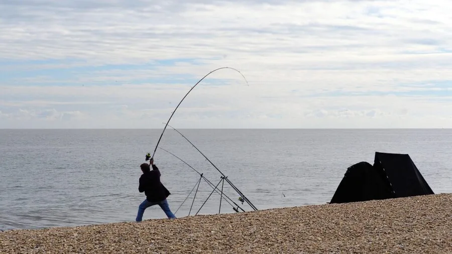 Fisherman demonstrating rod bend and casting technique while fishing in natural water setting