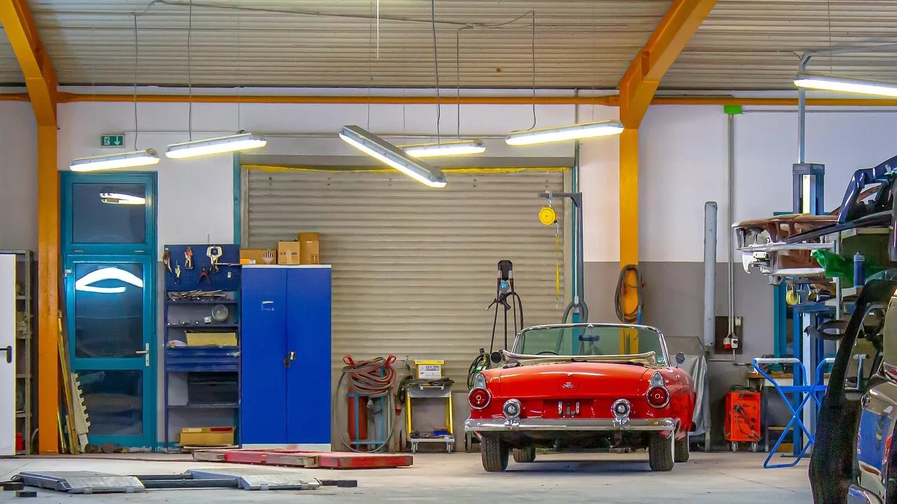 Floor jack lifting car in garage workshop