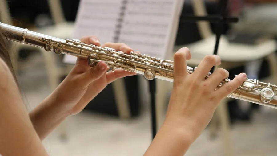 Focused musician wearing headphones during practice session with instrument