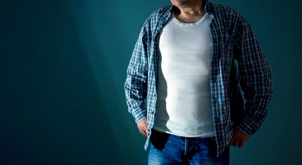 Folded white men's undershirts displaying classic cotton tank tops and t-shirt styles