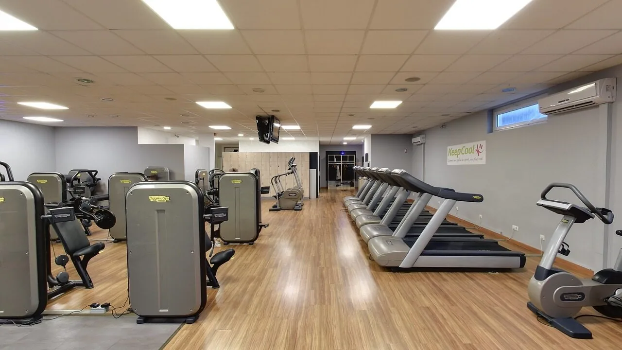 Folding treadmill in compact home gym setup showing foldable design and display console