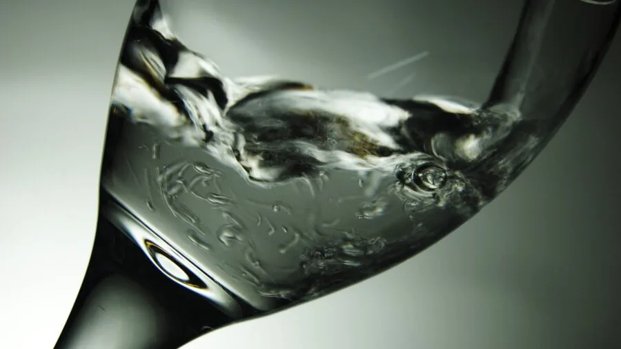 Fresh water being poured into a glass, representing water filtration and purity
