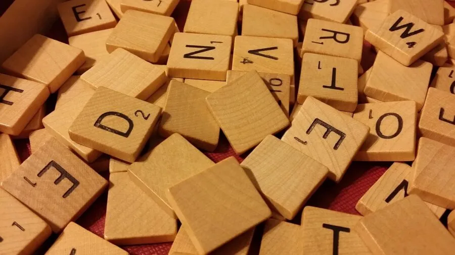 Friends of different ages gathered around a table playing a tabletop board game indoors