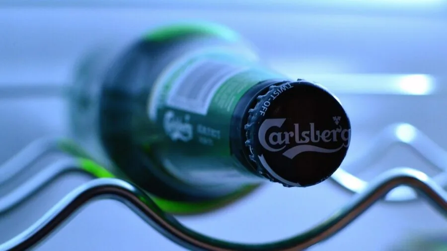 Glass jar of cold brew coffee stored in a refrigerator with fresh ingredients nearby