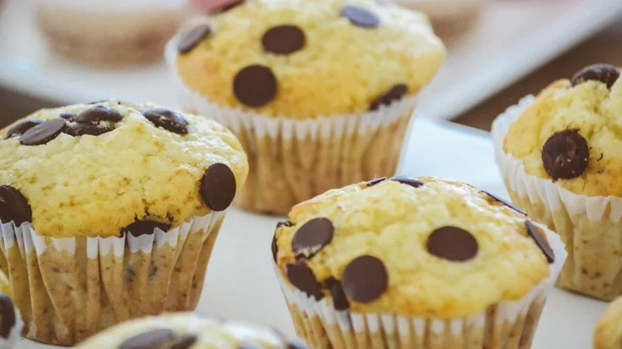 Golden baked muffins cooling on a kitchen counter in natural light