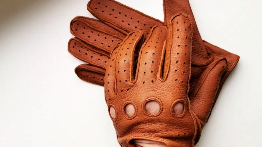 Golfer inspecting golf glove material and construction in natural daylight