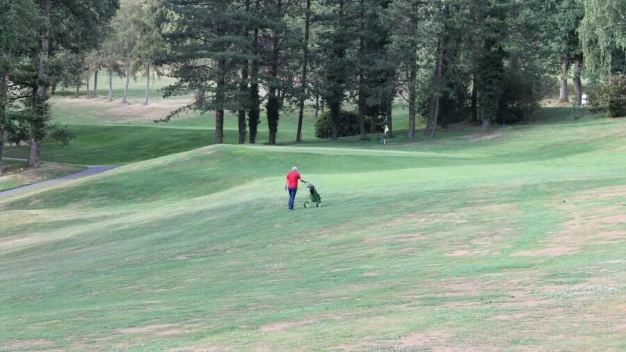 Golfer on fairway checking yardage during round of golf