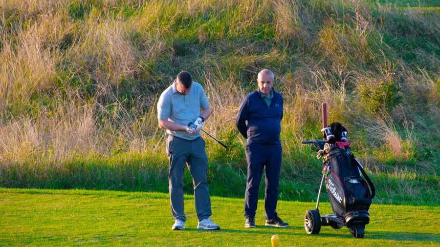 Golfer playing in rainy weather conditions on golf course