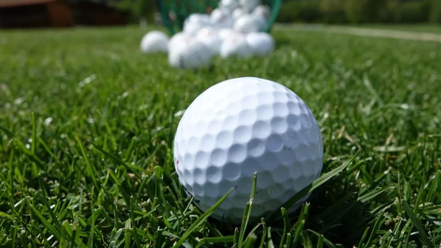 Golfer wiping golf club with towel during outdoor game on grass course