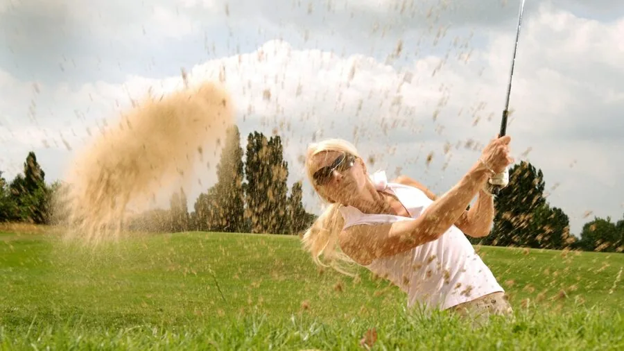Golfer wiping golf club with towel during round on course