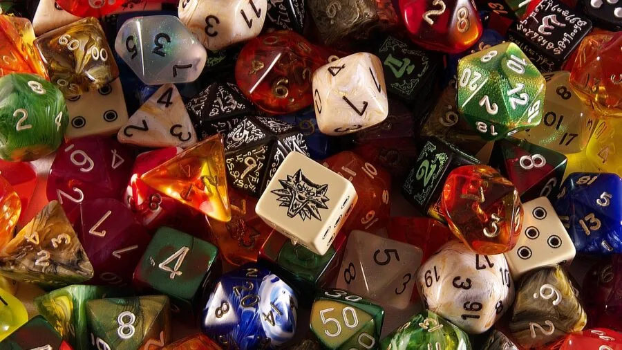 Group of friends gathered around playing a dice game together at a casual outdoor party