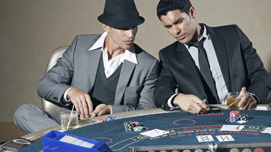 Group of people gathered around a table playing poker in a casual home setting