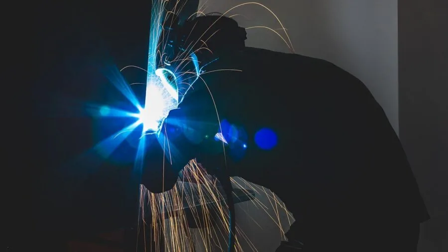 Group of workers discussing safety equipment and protective gear in an industrial workplace setting