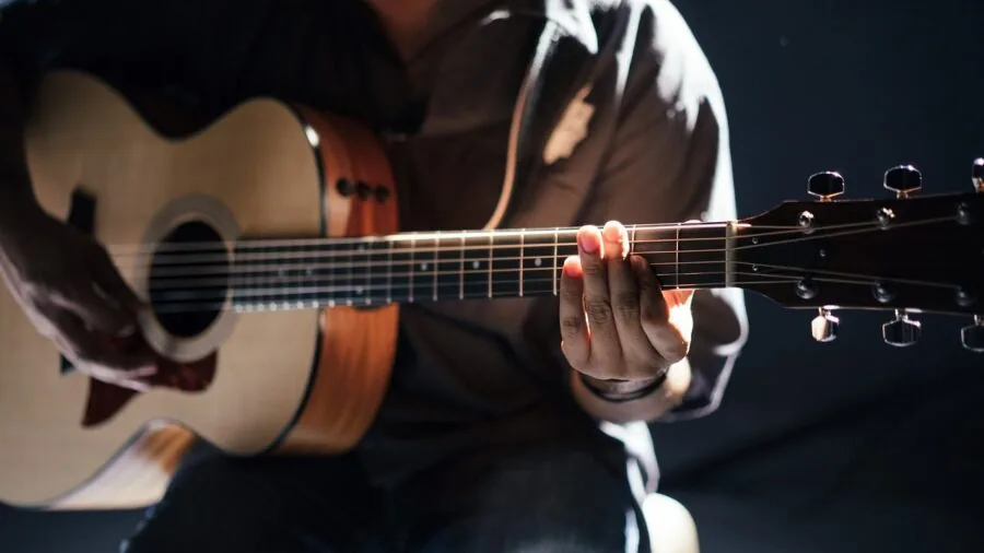 Guitarist performing with solid body electric guitar in natural lighting