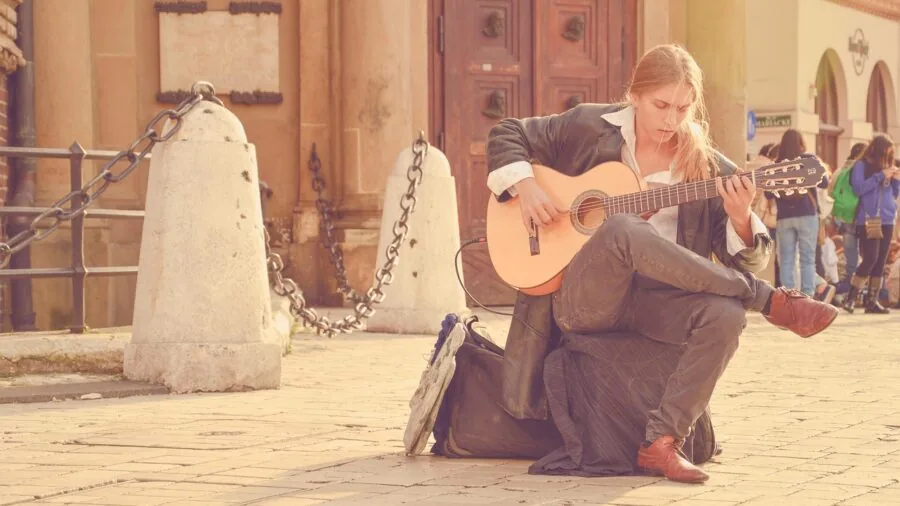 Guitarist playing acoustic-electric guitar connected to amplifier during live performance