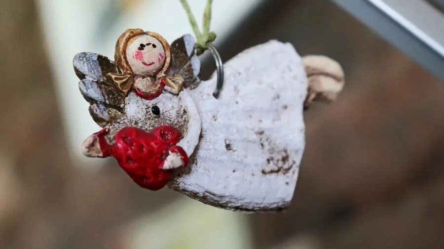Hands carefully sculpting and painting detailed miniature decorative models on a wooden workspace