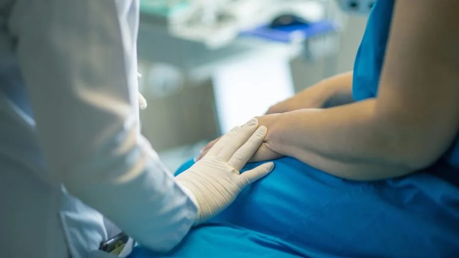 Healthcare professional checking patient's oxygen saturation with medical monitoring equipment