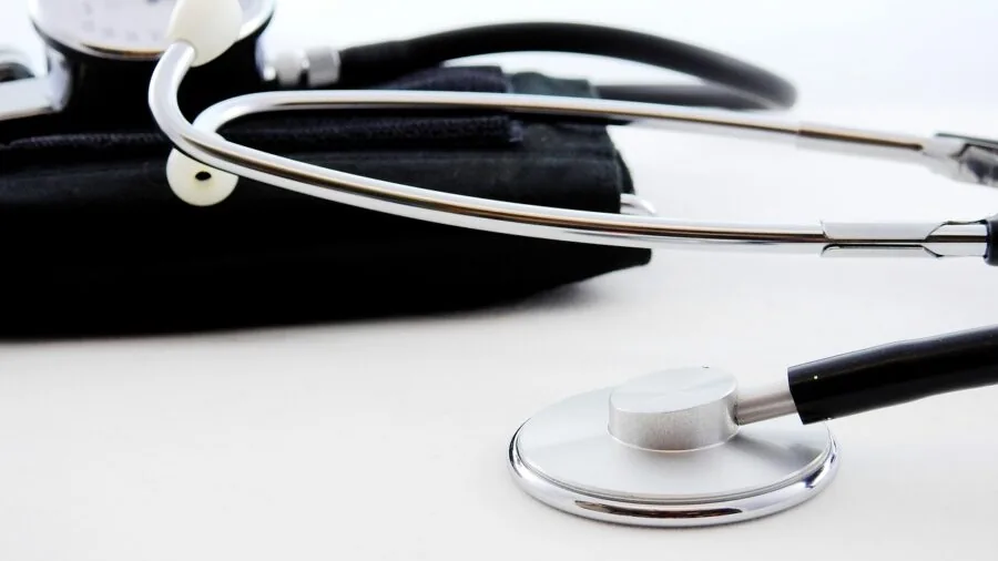 Healthcare professional measuring patient's arm blood pressure during medical consultation