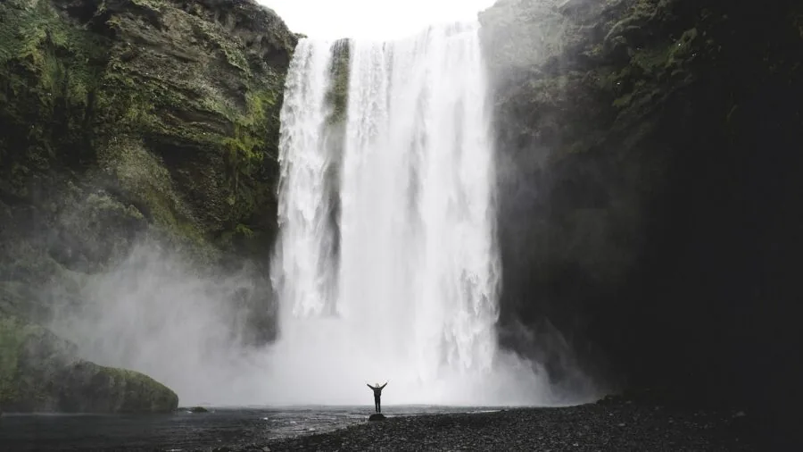 Hiker drinking fresh water from a natural stream during outdoor adventure