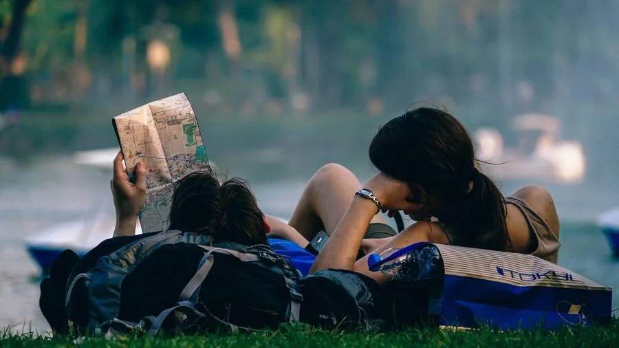 Hiker reading map in dark forest during nighttime navigation adventure