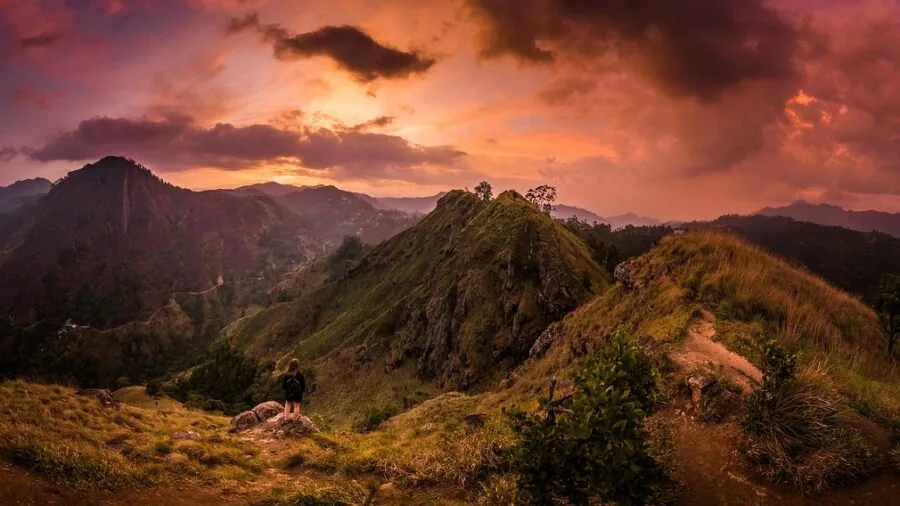 Hiker with lightweight backpack on mountain trail during golden hour