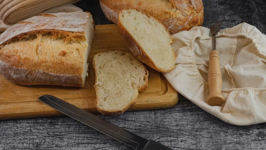 Home baker frosting muffins in a bright kitchen with affordable baking tools