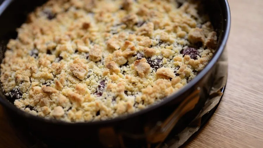 Home baker preparing springform pan for cheesecake in bright kitchen