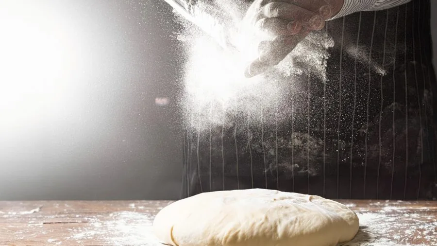 Home baker working with dough on baking mat in bright kitchen workspace