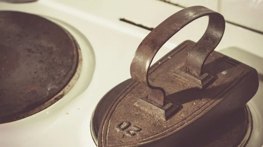 Home cook preparing meal in cast iron cookware on stovetop, demonstrating heat distribution and retention