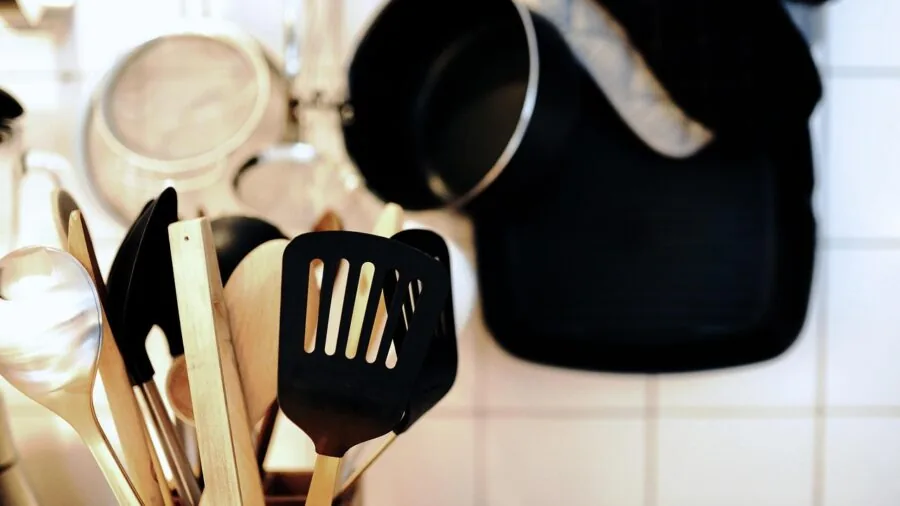 Home cook using griddle pan safely in modern kitchen with proper handle grip technique