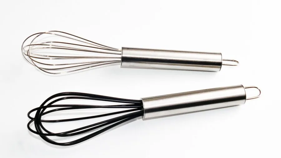 Home cook using various kitchen tools while preparing food at countertop