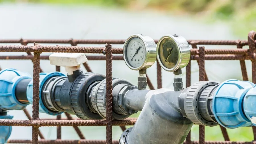 Homeowner installing smart sprinkler controller wiring in residential irrigation system