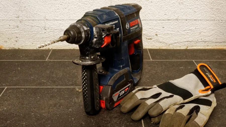 Homeowner organizing cordless tool batteries in garage for yard work