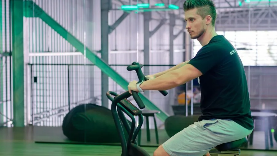 Individual adjusting stationary bike seat for proper ergonomic positioning during workout