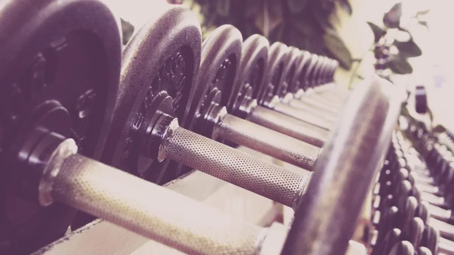Individual carefully assembling workout equipment, focused on proper joint connections and structural integrity
