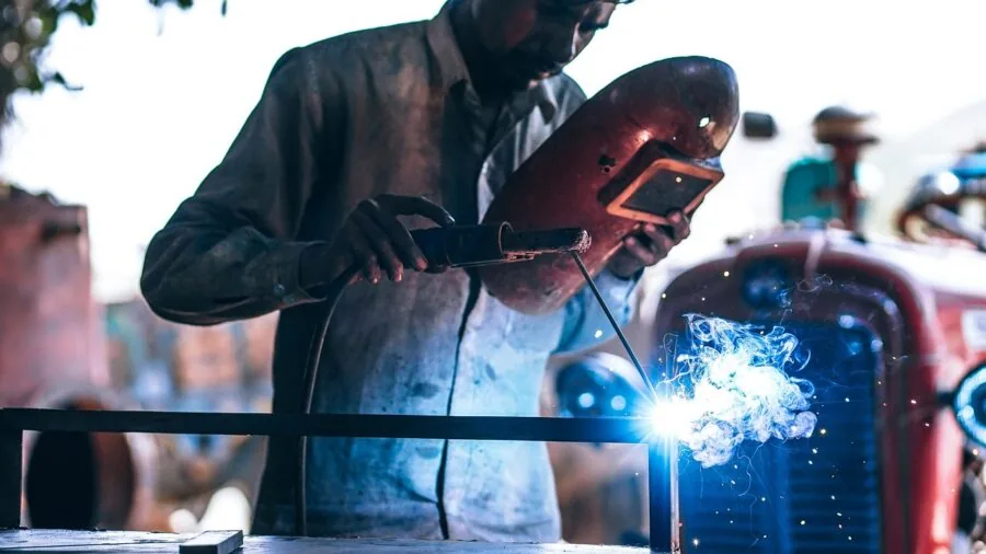 Industrial worker wearing safety gear and protective equipment in manufacturing facility