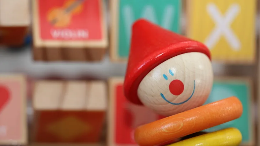 Infant examining natural wooden toy with hands in bright playroom setting